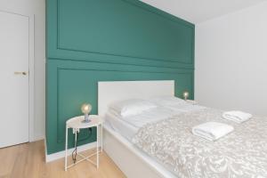 a bedroom with a bed and a side table at Apartamenty Letnicka by Renters in Gdańsk