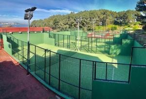 ein leerer Tennisplatz mit Licht oben in der Unterkunft Apartamentos Canabal in A Coruña