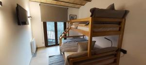 a room with two bunk beds and a television at Can Triadú in Camprodon