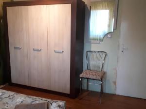 a chair sitting next to a cabinet in a room at Tulips - guest room close to the Airport, free street parking in Sofia