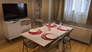 una mesa de comedor con platos rojos y copas de vino en Tarter Cozy studios by Renttarter Sans Espais, en El Tarter