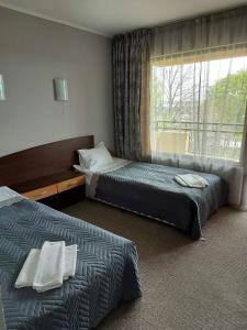 a hotel room with two beds and a window at Hotel Sveti Nikola in Sliven