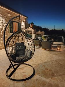 a bird cage sitting on a patio at night at Secluded Holiday home HERITAGE in Postira