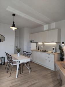 a kitchen with white cabinets and a table and chairs at Secluded Holiday home HERITAGE in Postira