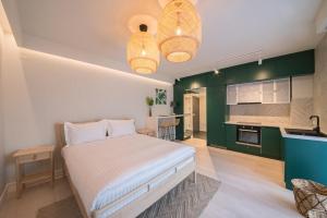 a bedroom with a bed and a kitchen with green cabinets at Biador Apartments in Oradea