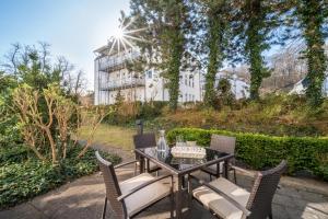 a patio with a table and chairs and a building at Villa Stranddistel Whg.1 in Binz
