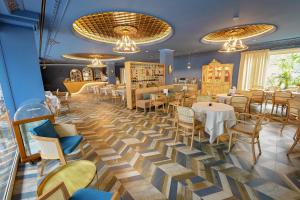 une salle à manger avec des tables, des chaises et des lustres dans l'établissement Çoçja Boutique Hotel, à Shkodër