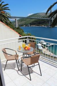 a table and chairs on a balcony with a view of the water at Apartments Lozica in Dubrovnik