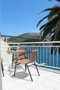 a balcony with a table and chairs and the ocean at Apartments Lozica in Dubrovnik