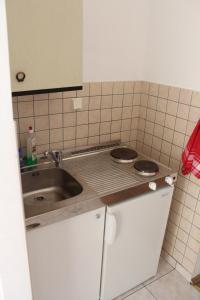 a small kitchen with a sink and a stove at Apartments Lozica in Dubrovnik