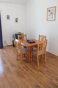 a dining room table with four chairs and a table at Apartments Lozica in Dubrovnik