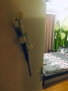 a door with flowers on the wall next to a bed at Tulips - guest room close to the Airport, free street parking in Sofia