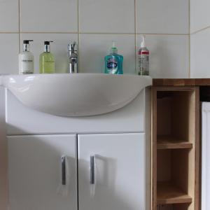 un lavabo blanco con botellas encima en Longmead House, en Lynton