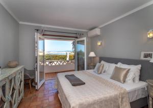 a bedroom with a bed and a balcony at Villa Atlantic Blue Luxury with Ocean views in Ferragudo +32 photos