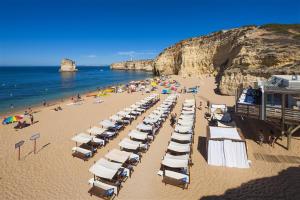 a beach with a bunch of chairs and people on it at Villa Atlantic Blue Luxury with Ocean views in Ferragudo