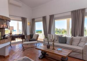 a living room with a couch and a table at Villa Atlantic Blue Luxury with Ocean views in Ferragudo