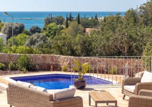 a patio with a pool and chairs and a table at Villa Atlantic Blue Luxury with Ocean views in Ferragudo