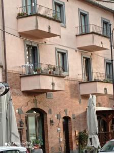 a building with balconies and an umbrella in front of it at Casa della Pondi in Bagnoregio