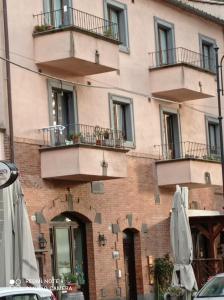 バニョレージョにあるCasa della Pondiのバルコニーと傘が前にある建物