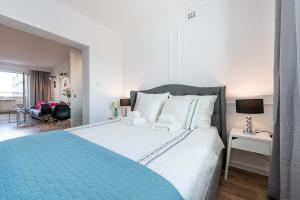 a bedroom with a large bed with a blue blanket at Poznanska Serviced Apartments in Warsaw