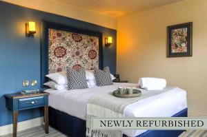 a bedroom with a bed with a newly refitted headboard at The George Hotel in Colchester