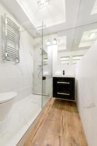 a bathroom with a glass shower and a sink at Poznanska Serviced Apartments in Warsaw