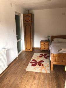 a bedroom with a bed and a rug on a wooden floor at Pensiunea Felyviss in Albac