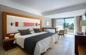a hotel room with a large bed and a balcony at Hipotels Natura Palace Adults Only in Playa Blanca