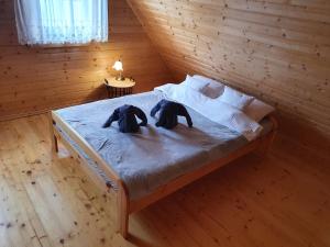 zwei Elefanten auf einem Bett in einem Holzzimmer in der Unterkunft Domek Gucio in Morąg
