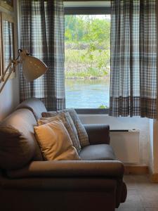 a couch sitting in a living room with a window at La Finestra sul Fiume in Valeggio sul Mincio