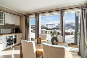 a kitchen with a table and chairs and a large window at Ustedalen Resort Leiligheter in Geilo