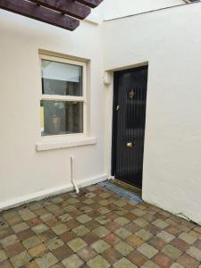 una porta nera e una finestra su un muro bianco di Dromod Lodge a Dromod