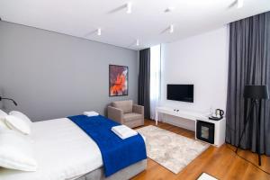 um quarto com uma cama grande e uma televisão em N Hotel BY NOSHI em Rinas