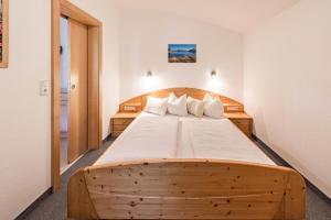 duże drewniane łóżko w pokoju z: w obiekcie Ferienwohnung Helena w mieście Schwendau