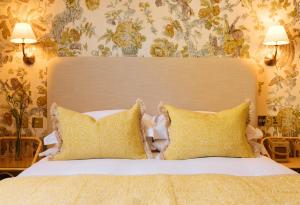a bedroom with a large bed with yellow pillows at The Yard in Bath Hotel in Bath