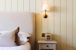 a bedroom with a bed and a table with a lamp at The Yard in Bath Hotel in Bath