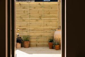 a wooden wall with potted plants in front of it at The Yard in Bath Hotel in Bath