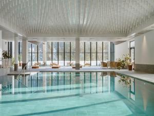 a large pool in a building with windows at Ambiez Residencehotel in Madonna di Campiglio