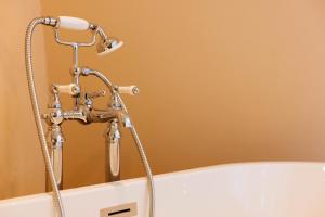 a bathtub with a water faucet in a bathroom at The Yard in Bath Hotel in Bath