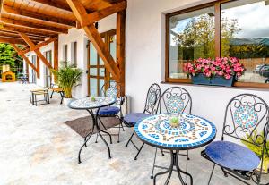 - une terrasse avec deux tables et des chaises dans l'établissement Yael Luxury Apartments 4, à Buşteni