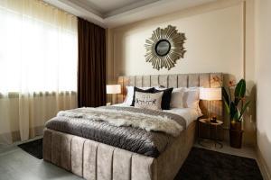 a bedroom with a large bed and a mirror on the wall at Qult - The Aristocrat in Bucharest