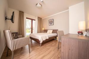 1 dormitorio con 1 cama, mesa y sillas en Hotel TiekZwei - Ihr Studiohotel, en Meppen