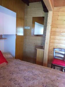 1 dormitorio con 1 cama y 1 silla roja en Casa Laika, en Maissana
