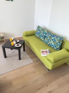 a living room with a green couch and a table at Sea star apartments in Rijeka
