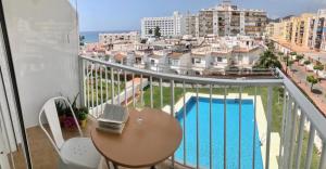 balkon ze stołem i widokiem na basen w obiekcie Edf. Gaviota 3º2 w mieście Nerja