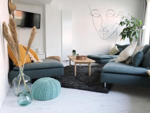 - un salon avec deux canapés bleus et une table dans l'établissement NYAMAN, à Ostende