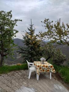 a table and a chair with a floral table cloth on it at Casa Laika in Maissana