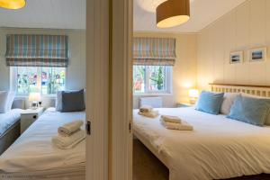 1 dormitorio con 2 camas y toallas. en Langdale Lodge, en Windermere