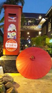 un paraguas rojo sentado en el suelo junto a un edificio en Baanfai Guesthouse Chiangkhong en Chiang Khong