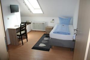 um quarto com uma cama, uma escrivaninha e uma cadeira em Gasthof Berg em Höchstädt an der Donau
